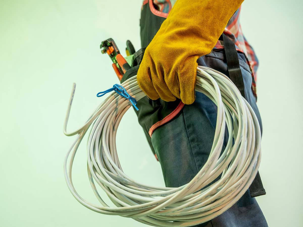 An electrician holding a coil of wires