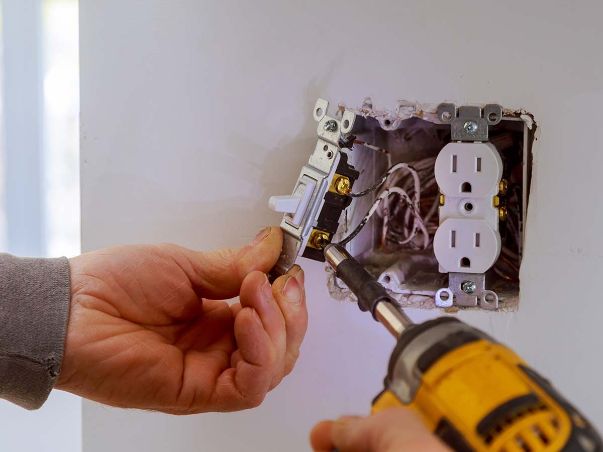 An electrician installing a lightswitch