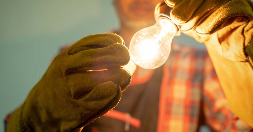 An electrician installing a light bulb