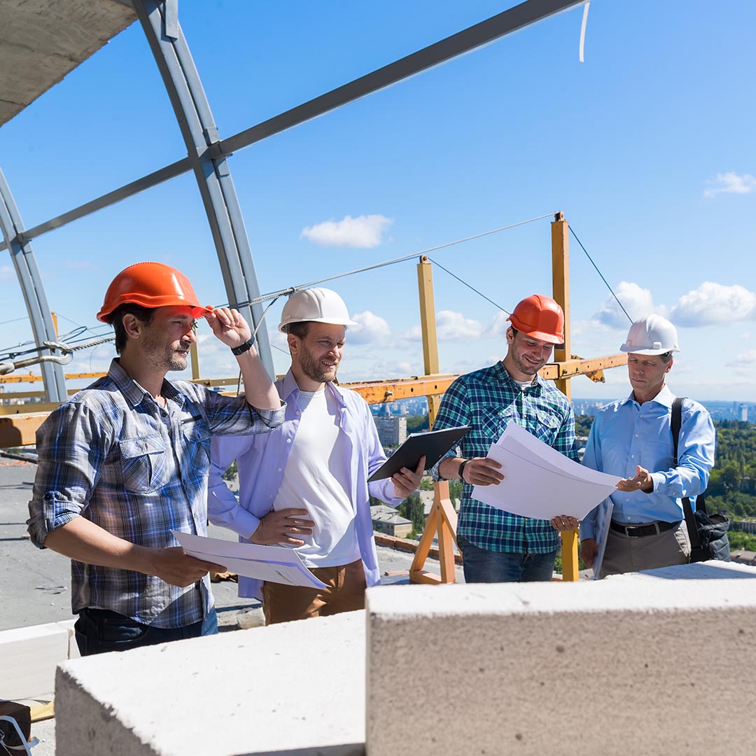 construction workers and electricians looking over building plans