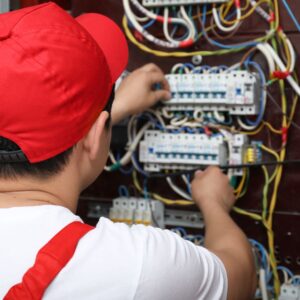 a professional electrician working on a large fuse box