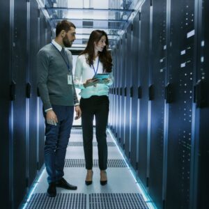 Two employees checking servers in a data center